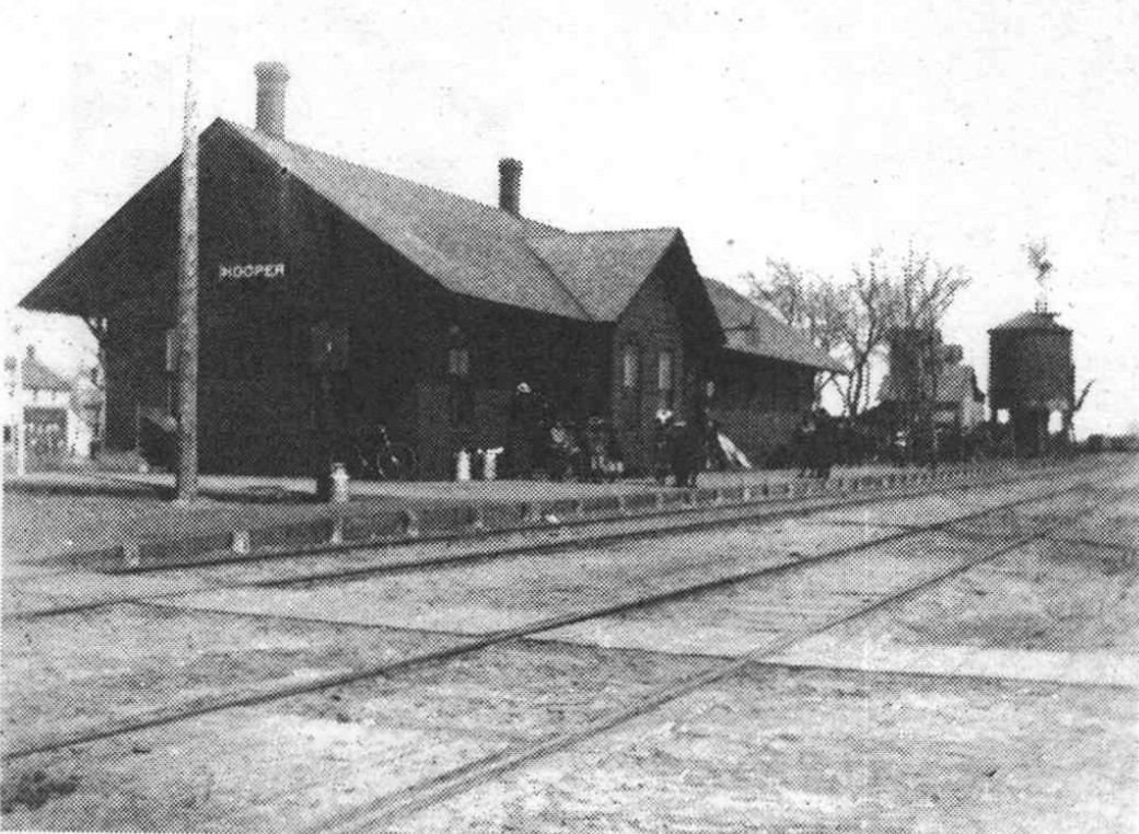 Hooper depot with tracks in the foreground and a water tank in the distance.
