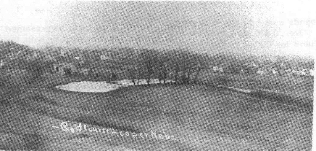 An early Hooper golf course with the town beyond it, reproduced in the centennial book; photograph undated.