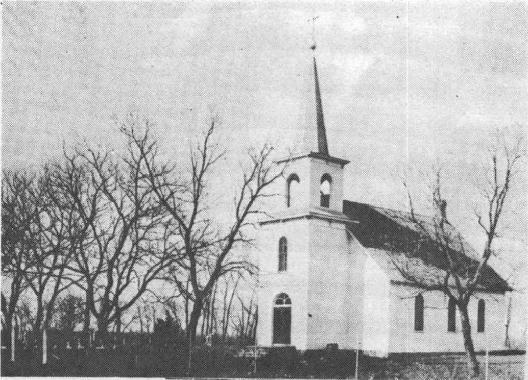 Historic photograph of Elim Lutheran Church with a white steeple and trees around the grounds.