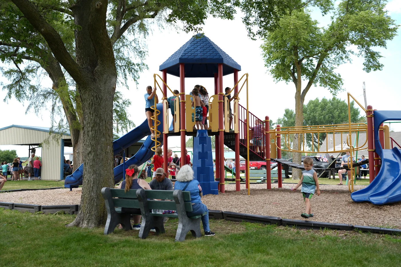 Children playing on the playground while neighbors visit at Hooper’s park during the 2026 celebration